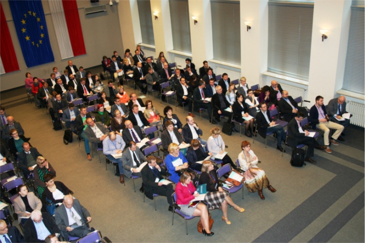 Widok na salę z góry, na której siedzą uczestnicy konferencji.