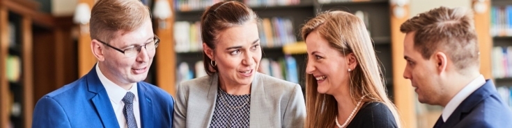 uśmiechnięci młodzi ludzie w bibliotece KSAP 